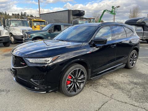 A black 2023 Acura MDX with a sporty design features a bold front grille red brake calipers and stylish alloy wheels