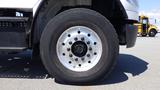 A close-up view of a 2017 Freightliner M2 106 wheel featuring a shiny aluminum rim with multiple bolt holes and a robust tire