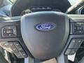 Steering wheel of a 2019 Ford F-350 SD featuring the Ford logo and various control buttons for navigation and audio settings