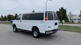 A white 2017 Chevrolet Express Quigley 4x4 van parked with a sleek body and chrome wheels