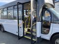 A 2017 Chevrolet Express with an open door revealing a step inside the bus and yellow grab bars for assistance