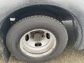 Close-up of the tire and wheel of a 2018 Chevrolet Express showing a silver rim with lug nuts and a black tire with a textured tread pattern