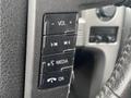 Close-up of the steering wheel controls in a 2014 Ford F-150 featuring buttons for volume media and ok functions