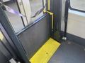 A 2017 Chevrolet Express interior showing a yellow wheelchair ramp in a lowered position with a metal mesh panel