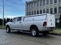 A silver 2012 RAM 3500 pickup truck with a white truck bed cap parked on a street