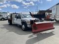 A 2010 Ford F-550 truck with a red snowplow attached to the front facing forward