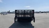 A black 2019 Ford F-550 truck with a flatbed and mesh sides is viewed from the rear in a parking lot