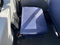 A folded blue seat from a 2017 Chevrolet Express with a black panel beside it