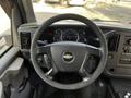 The interior view of a 2015 Chevrolet Express showing the steering wheel and dashboard with gauges and controls