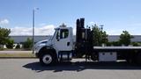 A 2017 Freightliner M2 106 truck with a black boom lift attached to the back parked on a lot