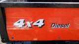 A close-up view of the side of a 2013 Kubota RTV 1100 showing the orange panel with the text 4x4 Diesel