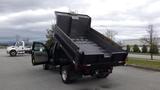 A 2008 Ford F-450 SD dump truck with its bed elevated, showing a flat, empty cargo area and an open driver side door