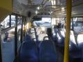 Interior of a 2016 Chevrolet Express with rows of blue seats and yellow handrails visible