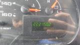 A close-up view of a vehicle's dashboard displaying the odometer reading of 2221502 miles with fuel and temperature gauges visible