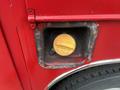 Close-up of the fuel cap of a red 2011 Ford F-250 SD showing a round gold fuel cap secured in a rectangular opening