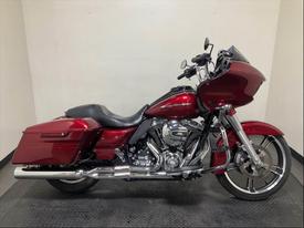 A 2016 Harley-Davidson FLTRXS motorcycle in shiny maroon with sleek lines and a large fairing showcasing its modern design and chrome accents