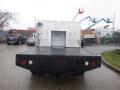 A 2009 Ford F-450 Super Duty truck with a flatbed and a metallic utility box mounted at the rear