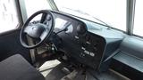 Interior view of a 2011 Ford Econoline dashboard featuring a steering wheel, gauges, control buttons, and the driver’s seat