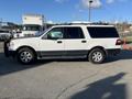 A white 2013 Ford Expedition with a black lower trim and alloy wheels parked on a paved surface