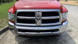 A red 2013 RAM 2500 pickup truck with a prominent black grille and chrome accents is prominently displayed in the foreground