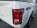 A white 2017 Ford F-150 with visible damage to the rear left corner and taillight