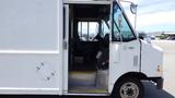 A white 2011 Ford Econoline with an open door revealing the driver seat and interior layout