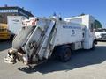 2010 Freightliner MT45 Garbage Truck with a waste collection body featuring a rear-loading mechanism and marked with a waste reduction program logo