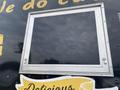 A metal window opening of a food truck with a gray frame and no glass, featuring yellow lettering on the truck's exterior