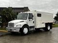 A white 2007 Freightliner M2 106 truck with a boxy cargo area and no visible logos is parked on a wet surface