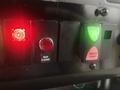 Control panel featuring a red warning light a button for rear flasher and a green master power switch