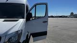 A 2016 Mercedes-Benz Sprinter with the driver's side door open and a clear view of the vehicle's front and side profile