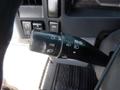 A close-up of the control stalk in a 2015 Isuzu NPR featuring switches for headlights wipers and cruise control settings