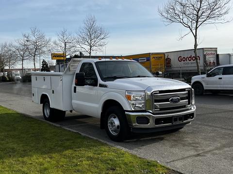 A 2016 Ford F-350 SD pickup truck with a white utility bed and orange lights on the roof