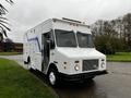 A white 2005 Workhorse W-Series truck with a blue stripe features a boxy design and multiple side compartments