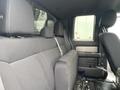 Interior of a 2014 Ford F-150 showing the back seat with black fabric upholstery and seatbelts