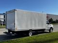 A white 2019 Ford Econoline box truck positioned on a grassy area with a plain cargo area and no visible branding