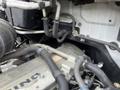 Close-up view of the engine compartment of a 2008 Hino 268 revealing components such as pipes and hoses connected to the engine block