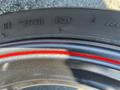 Close-up of a black motorcycle tire with a red stripe featuring tire specifications including the number 1521