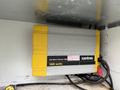 A yellow and gray Xantrex sine wave inverter labeled 1800 watts mounted inside a compartment