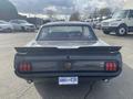 A classic 1966 Ford Mustang in gray with a distinctive rear spoiler and dual red taillights showcasing its iconic design and vintage appeal