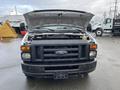 A 2013 Ford Econoline van with its hood raised showing the engine compartment and front grille