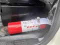 A red fire extinguisher secured in a holder with a label displaying safety instructions