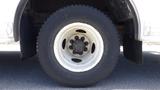 A close-up view of a white wheel with a black tire from a 2011 Ford Econoline showcasing the tire tread and wheel design