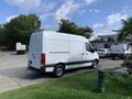 A white 2021 Mercedes-Benz Sprinter van parked on a grassy area with its side view visible