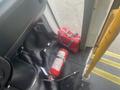 A red fire extinguisher and a red bag are on the floor inside a 2017 Chevrolet Express near the open door