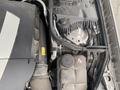 A close-up view of the engine compartment of a 2007 Mercedes-Benz E-Class showing various components including hoses and a reservoir