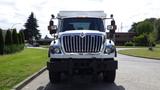 A white 2014 International 7500 truck with a prominent grille and multiple front lights is parked on a road