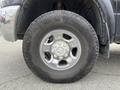 Close-up of a silver alloy wheel and tire on a 2010 Dodge Ram showcasing the intricate design and rugged tread pattern