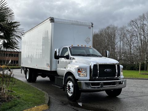 A 2022 Ford F-750 box truck with a white cargo area and chrome grill parked on a driveway