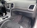 Interior of a 2018 Jeep Grand Cherokee showing the dashboard center console gear shift and floor mat